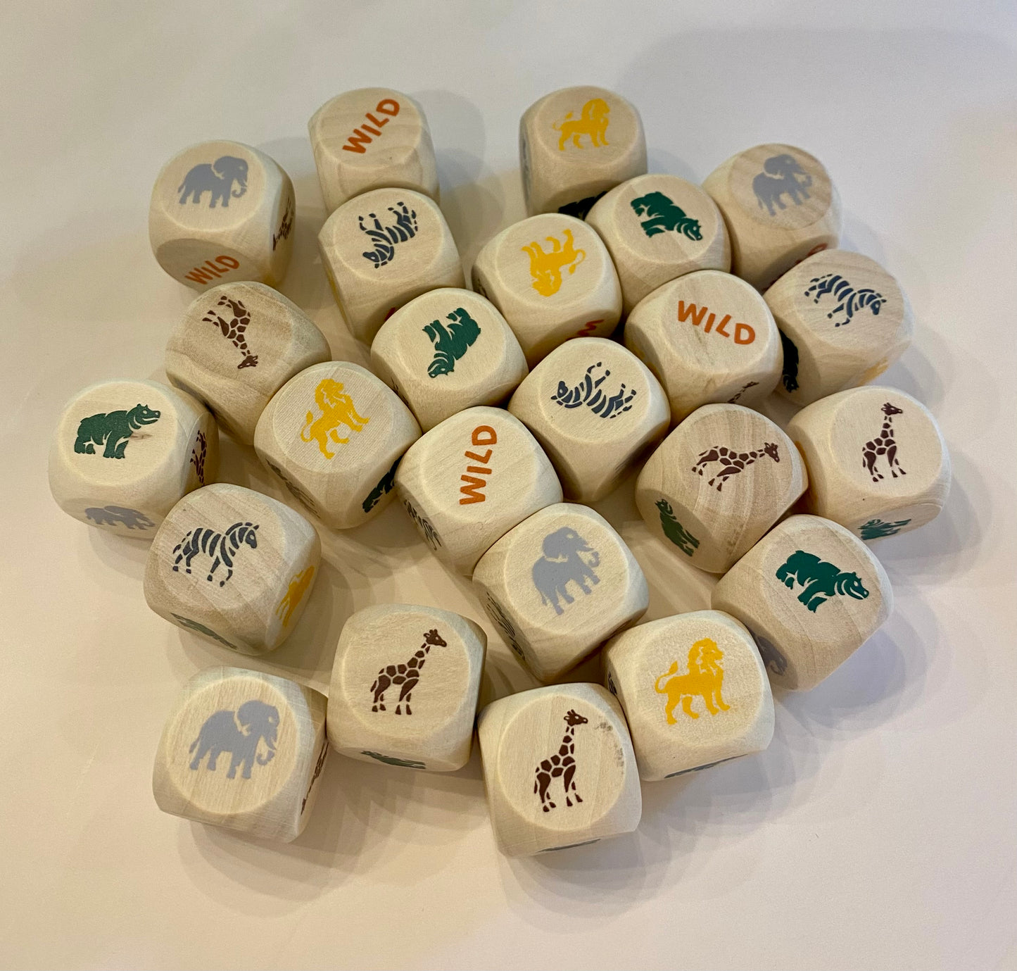 Set of wooden dice with animal and 'wild' prints on a white surface