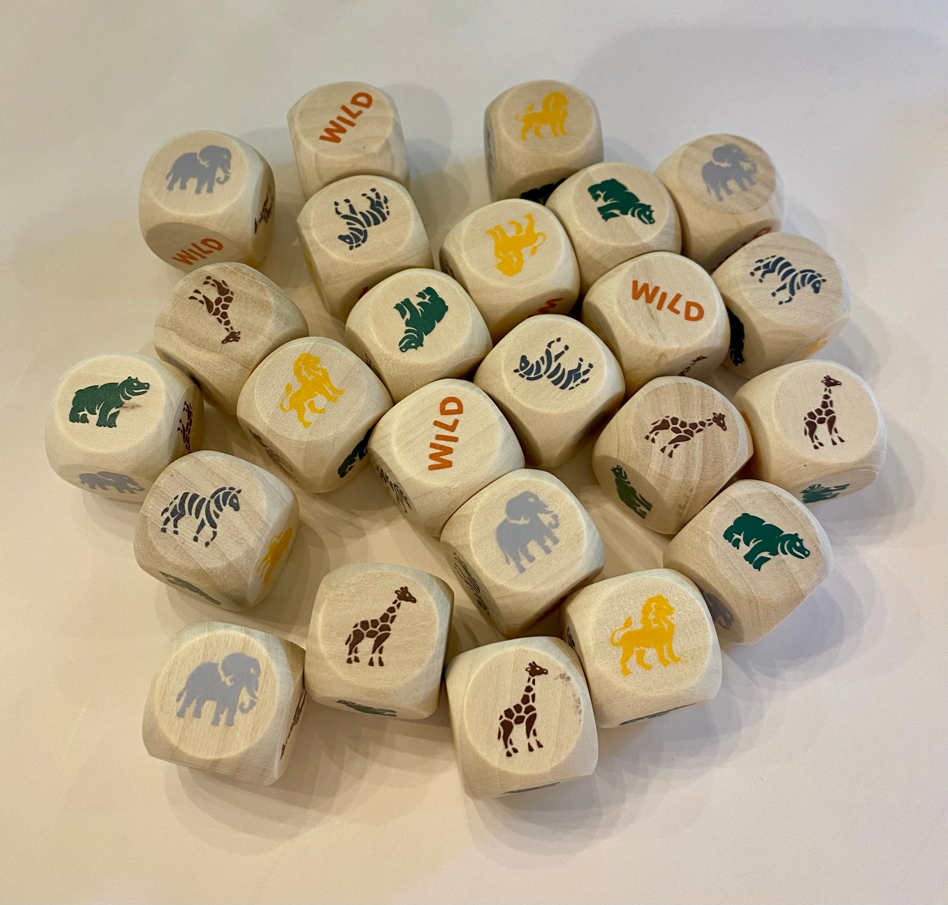Set of wooden dice with animal and 'wild' prints on a white surface