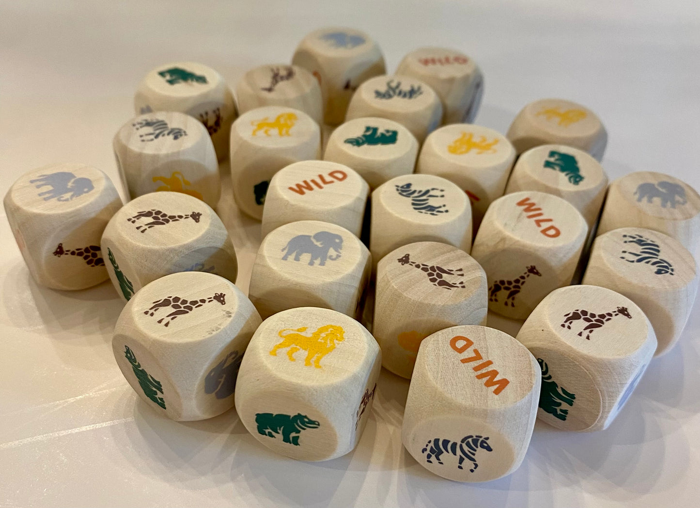 Set of wooden dice with animal and 'wild' illustrations on a white background